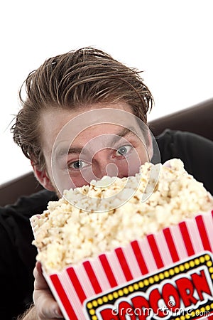 Man looking up from behind a popcorn bucket Stock Photo