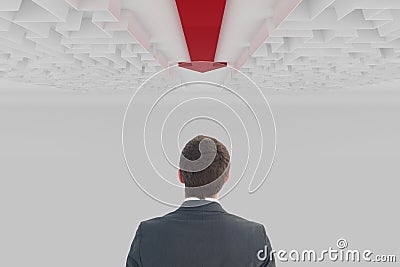 Man looking up to a maze with an arrow Stock Photo