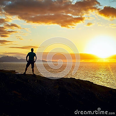 Man looks at the evening over the sea and the sunset on the Canary Islands in the evening light Stock Photo