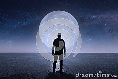 A man looks at the stars and the moon. Stock Photo