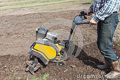 Man loosens the soil cultivator Stock Photo