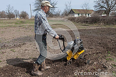 Man loosens the soil cultivator Stock Photo