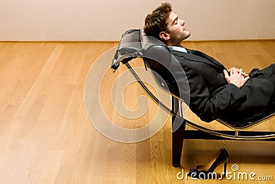 Man lying on chaise longue Stock Photo