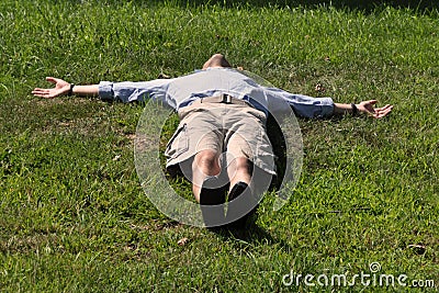 Man lying down like a cross Stock Photo