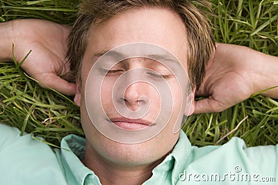 Man lying on grass sleeping Stock Photo