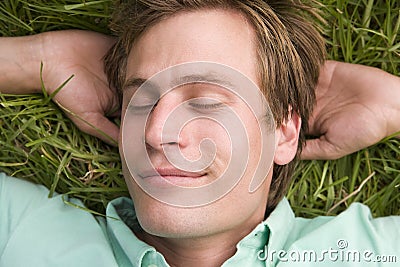 Man lying on grass sleeping Stock Photo