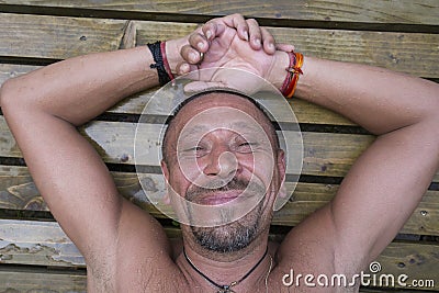 Man lying on a wooden pallet after a sauna. People and lifestyle concept. Happy middle-aged man outdoor, close up Stock Photo