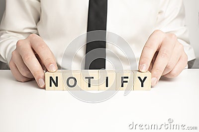 Man made word NOTIFY with wood blocks Stock Photo