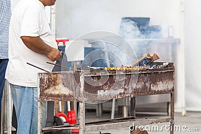 Man make Barbecue shashlik on an Iron Grill Editorial Stock Photo