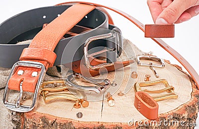 Man makes by hands leather belt with buckle. handmade hobby. young man resting by manufacture his designer belts. man with a screw Stock Photo