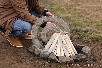 Man making bonfire outdoors, closeup. Camping season Stock Photo
