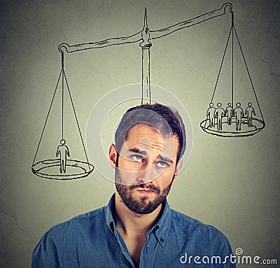 Man making a decision with scale above head and people on a balance Stock Photo