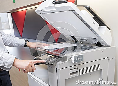 Man making photocopy of document on a copy machine with access control for key card. Stock Photo