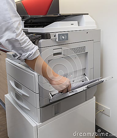 Man making photocopy of document on a photocopier machine with access control for key card. Stock Photo