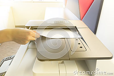 Man making photocopy with sheet of paper on Photocopier with access control panel. Stock Photo