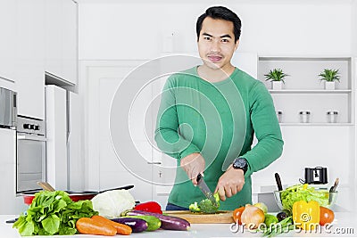 Man making salad in the kitchen Stock Photo