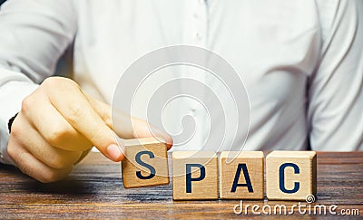 Man making SPAC word from blocks. in a row. A easy way stock exchange financial instrument for attracting investments Stock Photo