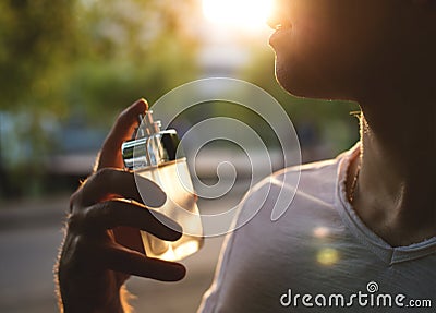 Man with male perfume over nature background Stock Photo