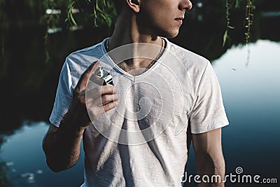 Man with male perfume over nature background Stock Photo