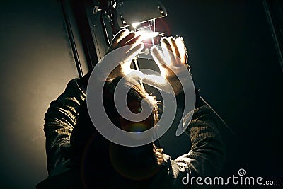 Man manipulating spot light with gloves in production studio Stock Photo