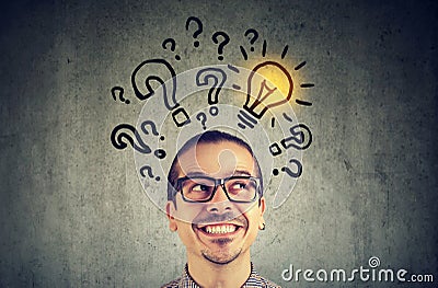 Man with many questions and solution light bulb above head Stock Photo