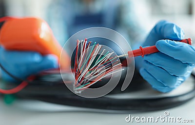 Man measuring voltage with special equipment, tool for checking pressure, bunch of wires Stock Photo