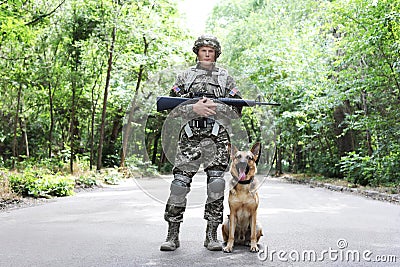 Man in military uniform with German shepherd dog Stock Photo