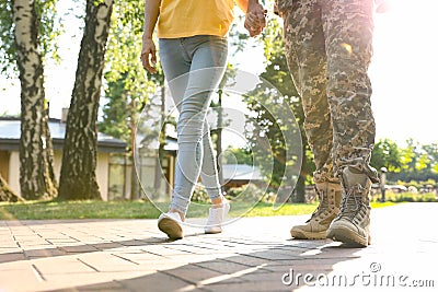 Man in military uniform walking with his girlfriend at park, closeup Stock Photo