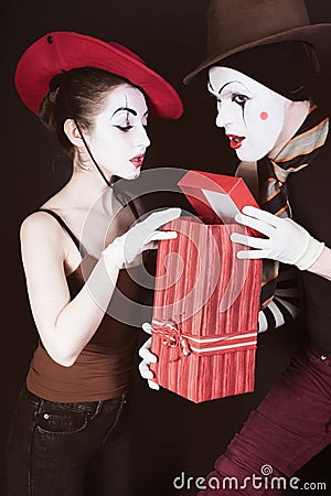 A man mime gives a gift to a woman Stock Photo
