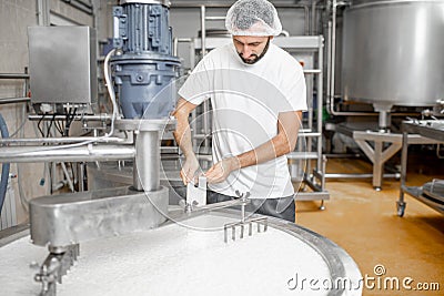 Worker at the cheese manufacturing Stock Photo