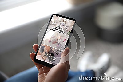 Man monitoring modern cctv cameras on smartphone indoors. Home security system Stock Photo