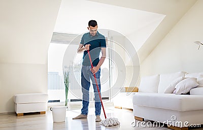 Man with mop and bucket cleaning floor at home Stock Photo