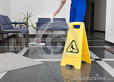 Man With Mop And Wet Floor Sign Stock Photo