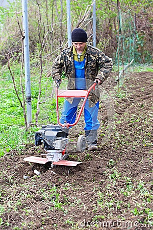 Man with motor cultivator against spring time Stock Photo