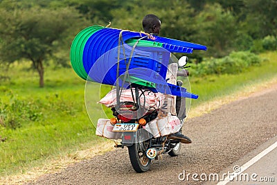 A man on a motorbike transports chairs in Uganda Editorial Stock Photo