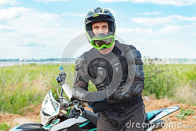 A man in motorcycle equipment sits on an enduro motorcycle Stock Photo