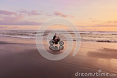 Man And Motorcycle On Ocean Beach At Beautiful Tropical Sunset. Biker Silhouette On Motorbike. Stock Photo