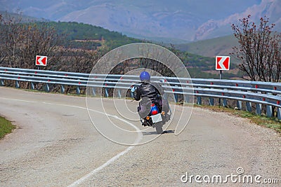 Man on a Motorcycle Turns on a Winding Road Stock Photo