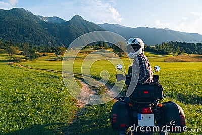 Man motorcyclist ride touring motorcycle. Alpine mountains on background. Biker lifestyle, world traveler. Summer sunny sunset day Stock Photo