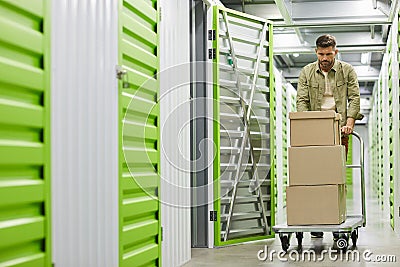 Man Moving Boxes in Self Storage Unit Stock Photo