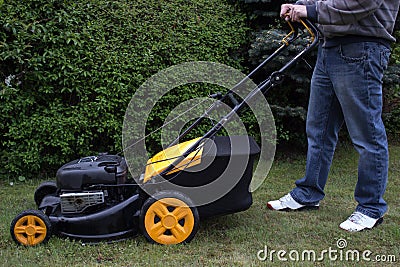 A man mows the grass with a gasoline mower Stock Photo