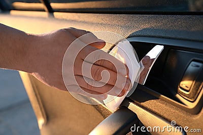 Man with napkin sanitizing car door handle, closeup Stock Photo