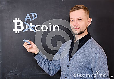 Man near a black school board on which is written bitkoin, part of the word Bitcoin is replaced by Bad Stock Photo