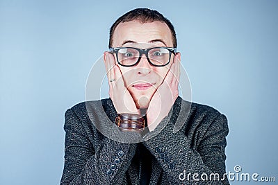 A man nerd freak with glasses and a gray stylish suit surprised and shocked Stock Photo