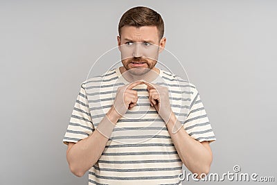 Man nervous, worried, connecting index fingers. Anxiety, uncertainty, doubts, shyness, awkwardness. Stock Photo