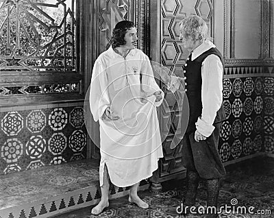 Man in a nightgown arguing with a man in the hallway Stock Photo