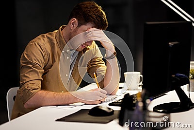 Man with notepad working late at night office Stock Photo