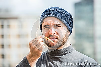 Man offering a french frie close up view - urban background Stock Photo