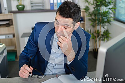 man in office touching eye Stock Photo
