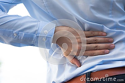 Man in office uniform having back pain issue / back injury Stock Photo